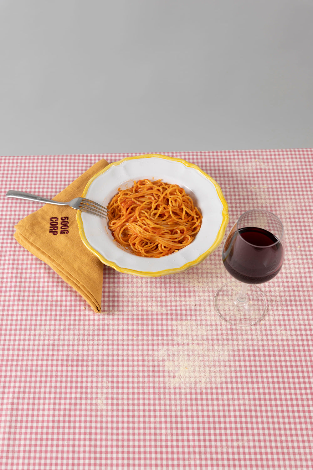 Assiette de spaghetti, vin rouge et serviette jaune 500GCORP.